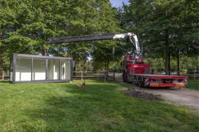 Kraanwagen plaatst een modulaire unit op locatie