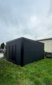 Zwarte modulaire opslagunit van ROBCOR op een grasveld in Destelbergen.