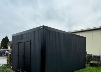 Zwarte modulaire opslagunit van ROBCOR op een grasveld in Destelbergen.