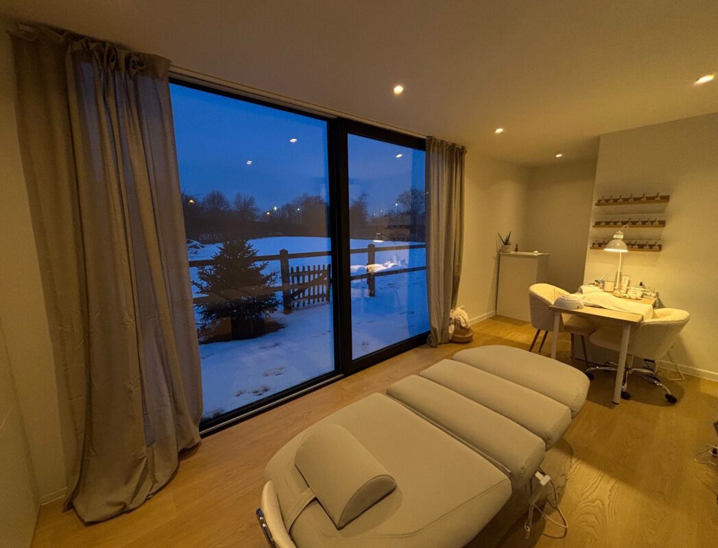 Modern beautysalon in een modulaire praktijkruimte van ROBCOR met behandelstoel en grote ramen.