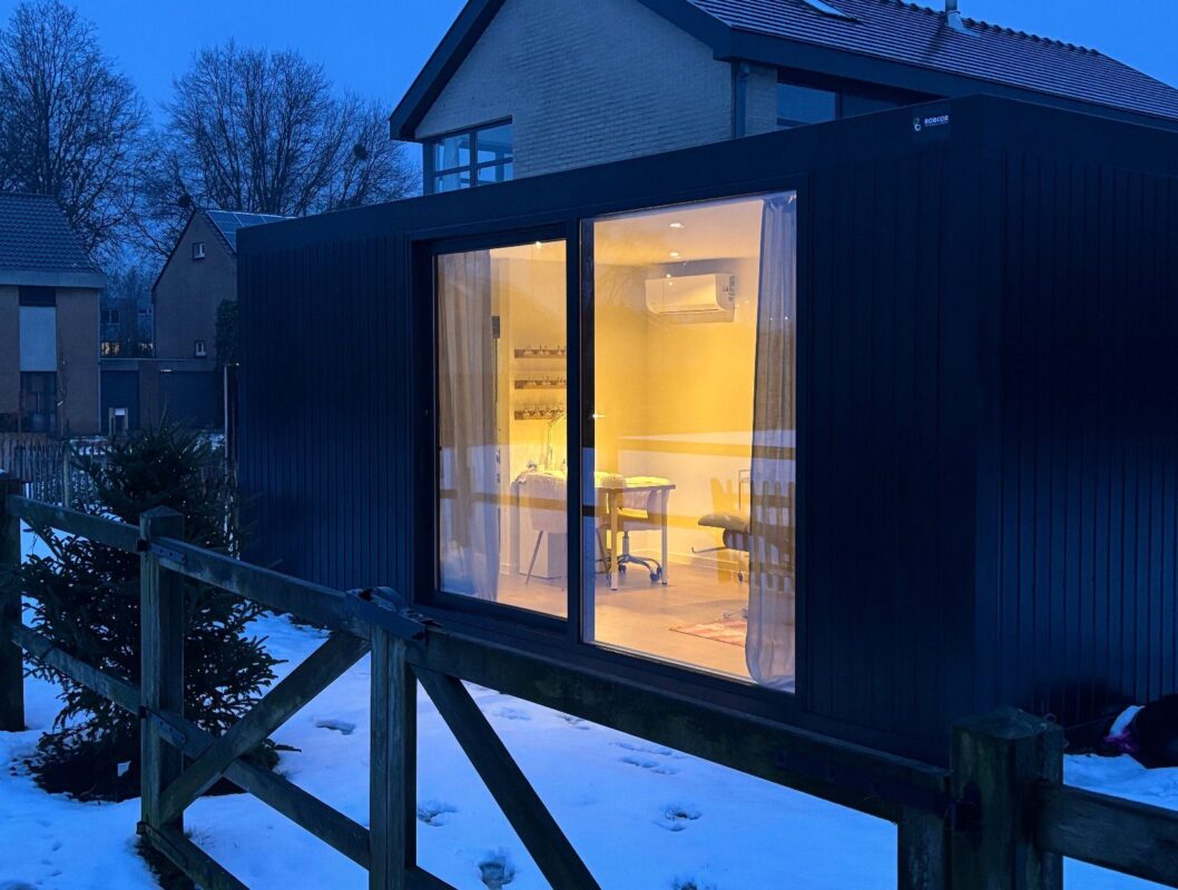 Verlichte praktijkruimte van ROBCOR als schoonheidssalon, met grote glazen deur naar de tuin.