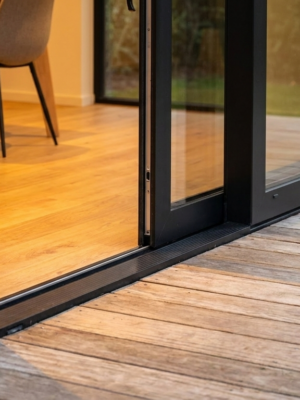 Drempelloze overgang van een modulaire zorgwoning naar een houten terras, toegankelijk en zonder opstap.